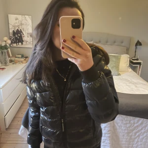 Peak performance jacka - Supersnygg svart glansig jacka från peak performance. Finns inte längre att köpa eftersom att det är en gammal modell. Köpt för 2 år sedan men är i superbra skick. Skriv till mig om ni har frågor eller för fler bilder. Nypris ca 3000kr