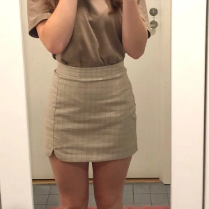 Minikjol - Söt minikjol! Beigefärgad med rutmönster i size S. Passar XS också! Kommer tyvärr inte till användning😇