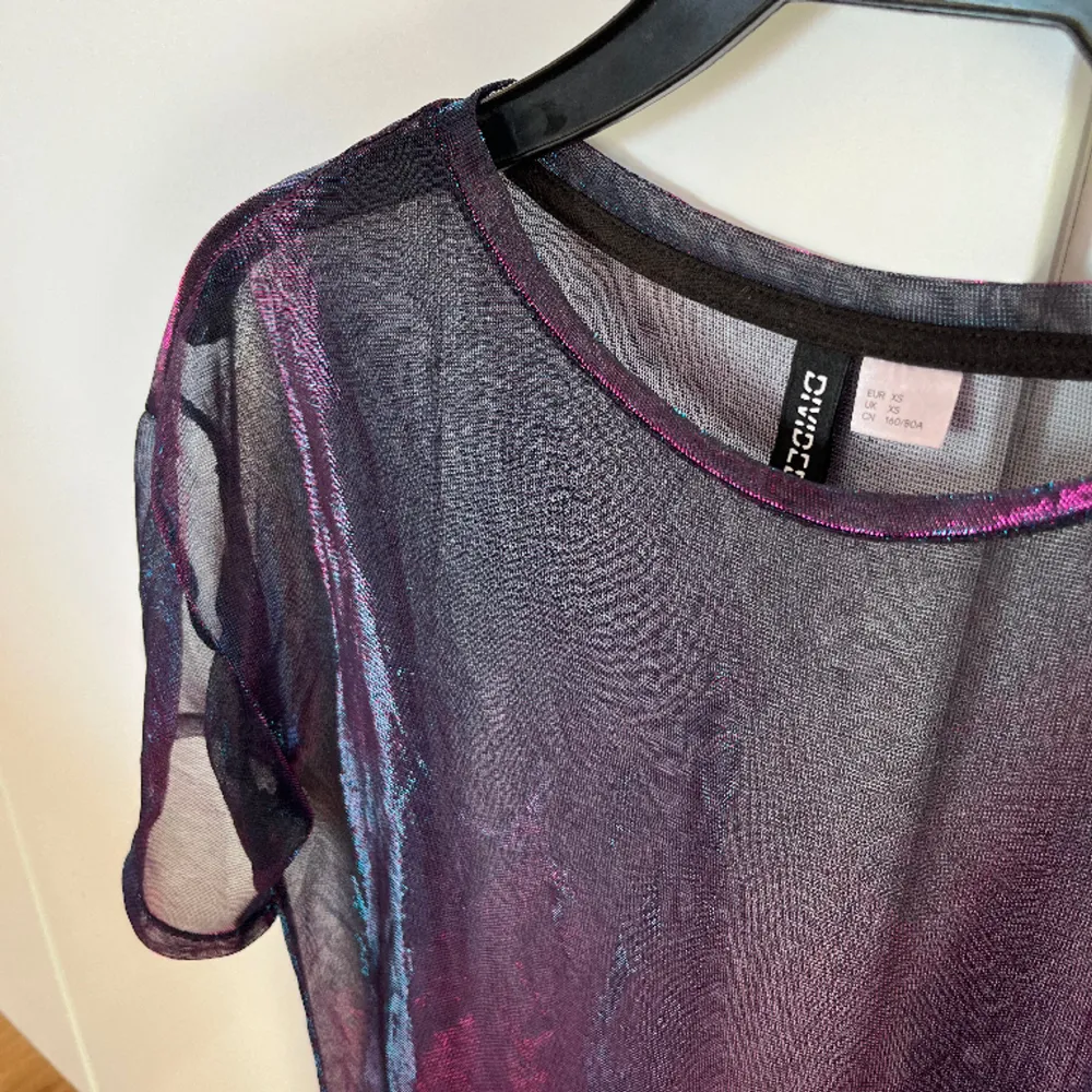 Skitcool tröja som syns! Meshtyg som skiner i lila/rosa/blått. Tyvärr kommer den inte till användning längre. Size XS men är oversized så skulle passa S och även säkert M också🥳. Yläosat.