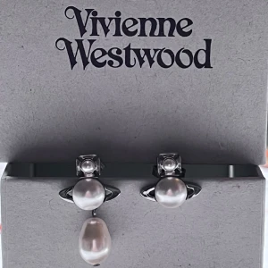 Vivienne Westwood örhängen - Originalbox och påse tillkommer. Man kan ta av den hängande pärlan. Köpta förra året på zalando men i nyskick då de inte kommer till användning, nypris är 1635 kr💕💕