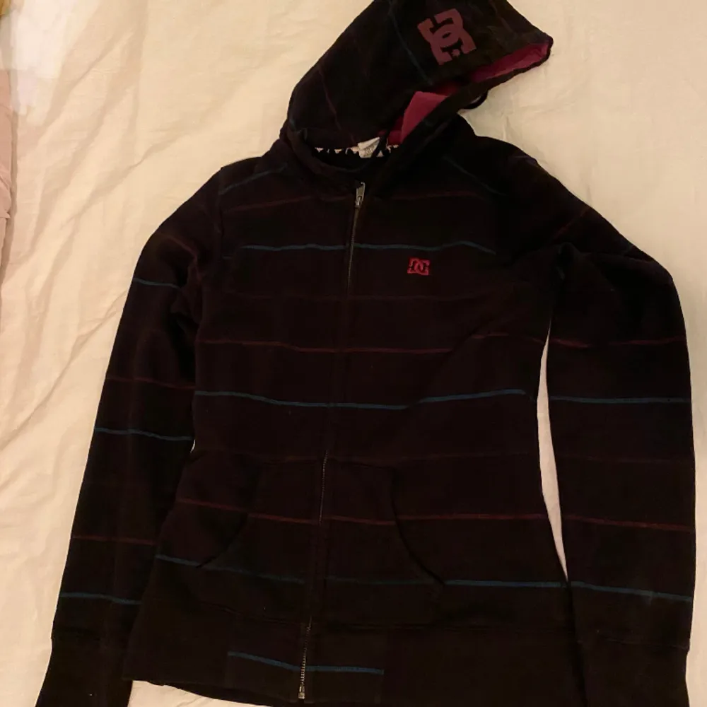 Skitsnygg ”DC shoes” zip-up hoodie, köpt på Beyond Retro men är i perfekt skick😸hoodien är brun med ränder och rosalila färg inuti luvan🙏🙏. Hoodies.