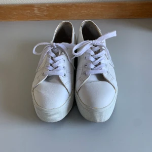 Vita sneakers - Säljer mina Superga i vit konstgjord läder. Använd skick, men ändå bra! Skriv om ni vill ha fler bilder😁