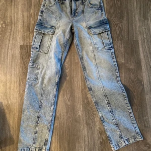 Cargobyxa jeans  - Helt nya, oanvända cargobyxor från HM. Storlek 36. Nypris 299:-. Obs- inga bakfickor! 