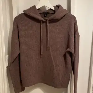 En hoodie som är brun och har luva med snören, skit snygg fast jag har ingen användning för den. Den är skön och i bra skick. 