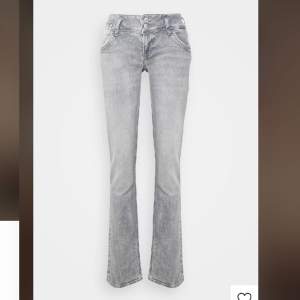 Snygga gråa lowwaist jeans från LTB. Dom är nästan aldrig använda och är i väldigt bra skick. Midjemåttet tvärs över är 33 men är stretchiga. Innerbenslängden är 73 och hela längden på byxorna är 98cm.