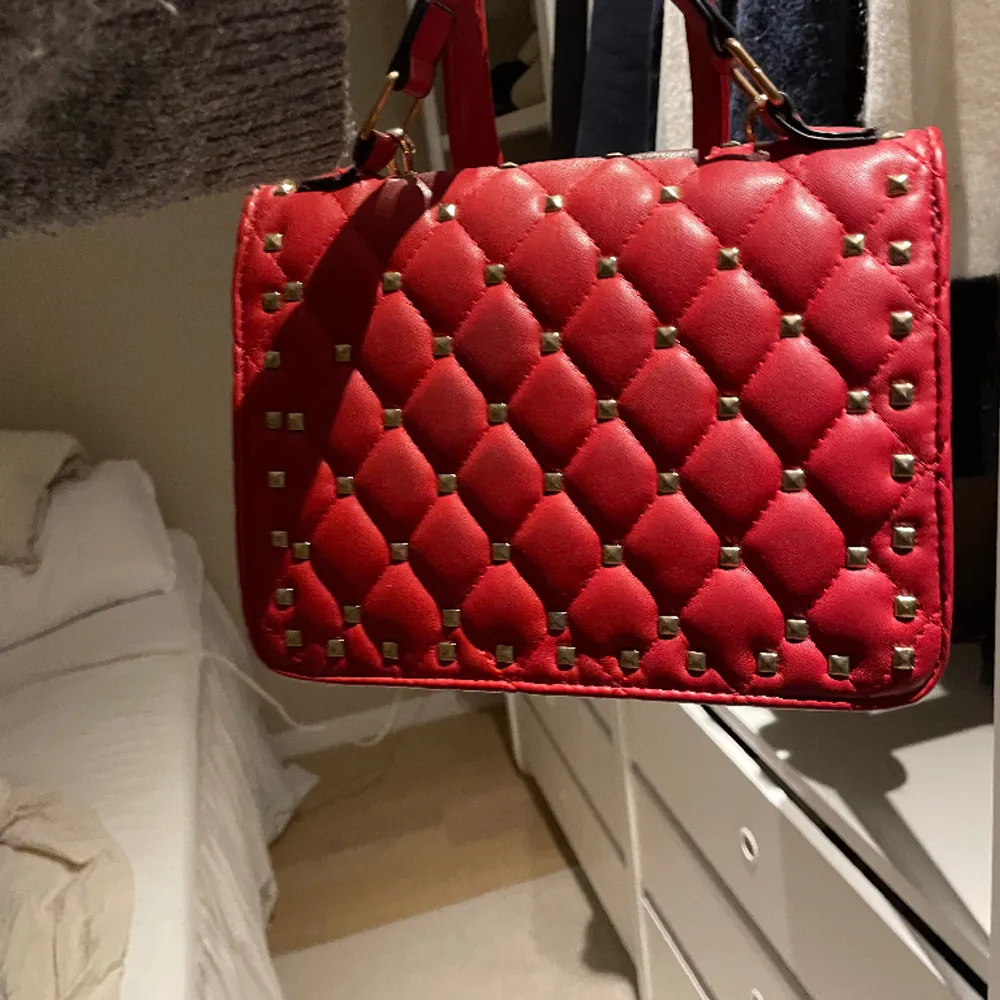 Säljer denna röda som liknar en valentino väska, den är lik Rockstud Spike Leather Handbagage. Pris är diskuterbart❣️❣️❣️. Väskor.