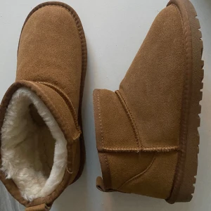 ”Uggs” i ultra mini  - Inte riktiga Uggs, men ser likadana ut och är i modellen classic ultra mini och färgen chestnut. Storlek 40, men är mer som 39 och därför för små för mig. Helt nya och endast testade. Står inget märke på dem! Köpt för 700kr! 