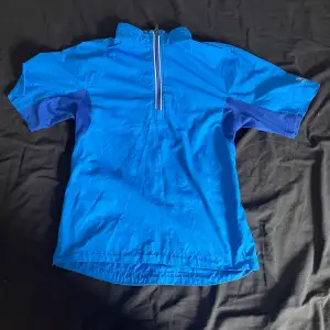 Blå Abacus golf tröja men en kvarts dragkedja. Den har två fickor och dragkedjor på sidorna.  Den har också ventilerande material vid armhålorna. Den är i storlek XS och helt oanvänd. Hör av er med frågor!