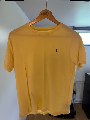 Ralph lauren t-shirt - Gul Ralph lauren t-shirt som har används max 3 gånger och därför är skicket prima (9/10 10/10)!😀 Tröjan passar personen med xs perfekt men funkar också för personen med S i storlek!