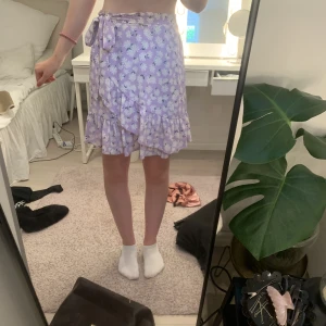Kjol - Blommig lila tjol från ONLY i storlek S med en knytning. 