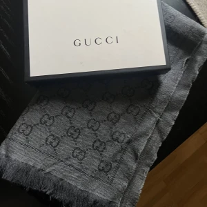 Gucci scarf  - GG Jacguard scarf. Köps för 3800kr i butik men pga någon tråd här och var som sticker ut så säljer den billigt! (Obs inga hål eller något som egentligen syns när den används)  Kommer även med påse och kartong.