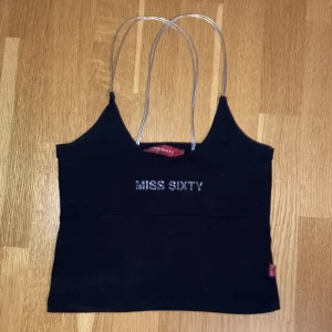 Miss Sixty topp med silver band och glitter 🩶 - ☆ Så snygg vintage Miss Sixty halter liknande topp~ ☆ I fint skick, använd några gånger. ☆ Storlek XS-S. Lite för tight på mig med strl 38. ☆ Kolla gärna in min profil för fler plagg och mycket y2k! 🖤