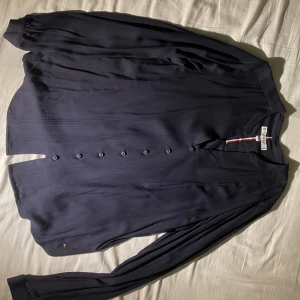 Marinblå blus Tommy Hilfiger - Marinblå blus med ett ribatt mönster längs sidorna samt subtila knappar i samma färg.