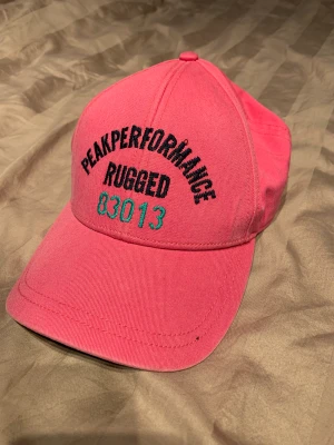 Peak performance keps - Söt keps från PeakPerformance i rosa/grön färg. Aldrig använd så i mycket gott skick! (Färgerna är klarare än vad som framgår på bild)