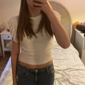 Topp med volangärmar - Säljer denna vita topp från Gina tricot då den ej kommer till användning. Jag har storlek xs och den passar. Är i mycket bra skick skriv gärna om frågor eller om fler bilder💕