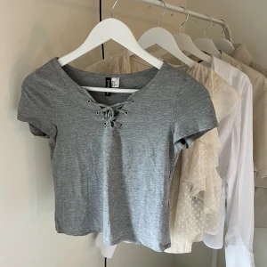 Grå t-shirt med snörning - Grå t-shirt med snörning från h&m, i strl S🤍