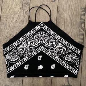 Svart mönstrat linne  - Svart bandana mönstrat linne, med korsade band i ryggen. 