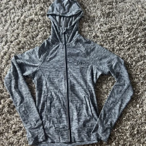 Träningströja  - Långärmad träningszipup med huva och fickor med dragkedja. Aldrig använd. 