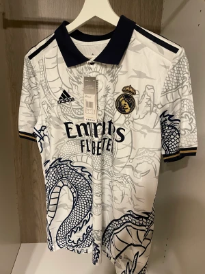 Realmadrid Drake tröja🐉 - Helt oanvänd fotbollströja med storlek S, tröjpåse medföljer. Kan fraktas i hela Sverige.😊