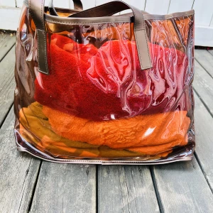 Beach bag/väska säljes 2 st - Beach bag för dam säljes.  Väskan är helt oanvänd.  I orange/genomskinlig.  Väl rymlig. Finns 2 st av samma modell.  Priset är per st.   ” för snabb affär kan priset sänkas ”