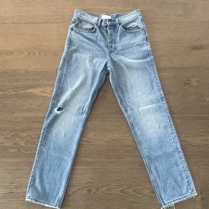 Ljusblåa jeans med slitningar.  - Jag säljer mina ljusblåa jeans med hål på höger ben och vänster ficka.  OBS, köpare står för frakt! 