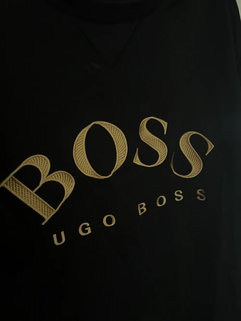 En svart Hugo boss t-shirt med loggan i guld på bröstet. Storlek L i herr. Använd ett par gånger men i gott skick. . Tröjor & Koftor.