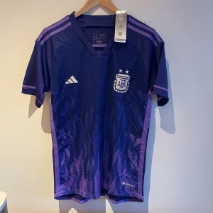 Argentina Fotbollströja  - Säljer helt ny Argentina fotbollströja🙌🏽. Köpt på Addidas hemsida, säljer för den var snäppet för stor för mig. Allt är helt nytt tagen är kvar och plastpåsen hönger med helt oanvänd🤗