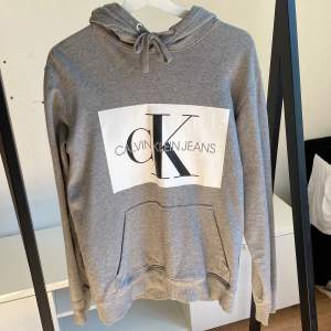 Grå Calvin Klein hoodie  Använd men inte särkilt sliten.  Storlek: M