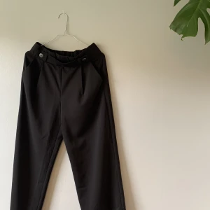 Halvlånga svarta tunna byxor - Stretch i midjan.