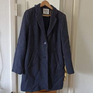 Long jacket. Two buttons, lined jacket with pockets.
