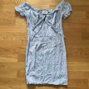 Blå blommig klänning - Stretchig klänning med lite ”puff” armar. Ganska kort klänning så man måste nog vara kortare än 165!