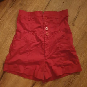 Röda shorts - Knallröda, högmidjade shorts från Gina Tricot i storlek 38. Säljes då jag aldrig fått dem till användning🙏😭