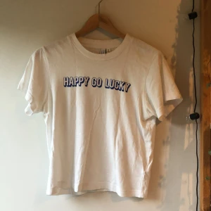 T-shirt  - Vit T-shirt med mörkblått tryck.