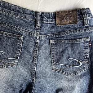 Lågmidjade jeans med coola fickor och i bra skick. Köpta secondhand. Storlek S men skulle nog passa M också. Skriv för mer bilder/info 