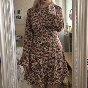 Blommig klänning - En ljuvlig och elegant blommig långärmad klänning i supermjukt material från Zara i strl S!🫶🏻Volangkant nedtill och vid ärmarna, samt sidodragkedja och knäppningsdetalj framtill!💓
