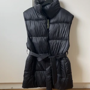 Väst - Väst med knyte runt midjan. Storlek S, stor i storleken. Aldrig använd, lappen är kvar.