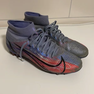 Nike Mercurial Superfly KM AG Fotbollsskor - DJ3978-506 i fint skick. Inga hål i sko eller hälkappa. Skosnörena har tappat plastniten i ändarna.