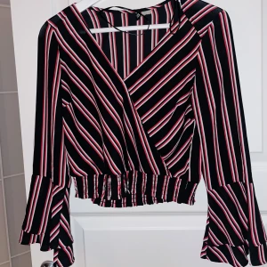 Röd svart randig crop topp med volanger - Använd 2-3 gånger men den är för liten. Inga skador eller fläckar såklart. Croppad och har volanger vid änden av ärmarna