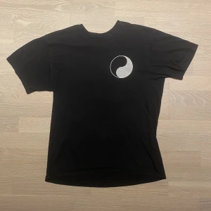 Our legacy x Stussy  - T-shirt från Our legacy x Stussy. Storlek 48. Använt skick med enstaka fläckar och ett mindre hål, därav lägre pris.
