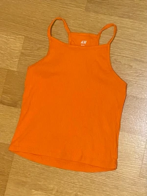 Orange crop top  - Orange crop top från H&M. Storlek 134. Har används endast en gång. I väldigt bra skick. Jag står inte för frakt