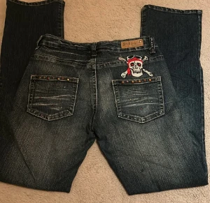 Seyoo lågmidjade flare jeans  - Säljer dessa as balla jeans som är lågmidjade och bootcut från Seyoo, vissa av stenarna har lossnat med det är inget som syns! Midjemått: 79cm  Innerbenslängd: 78cm 