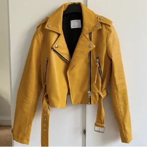 Mustard skinnjacka - Helt oanvänd skinnjacka frän Bershka i XS; Köpte 3 år sedan men är för liten på mig.