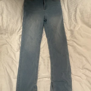 Jeans från Nelly  - Ljusblåa jeans från Nelly med slits. Använda ca 2 gånger. Nytt skick.