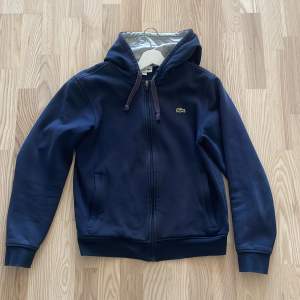 Mörkblå Lacoste zip up hoodie i gott skick! Meddela för fler bilder