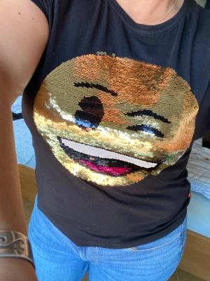 Tshirt med emoji  - Tshirt med paljetter på en sida glad och på den andra ledsen 😢, ha pytteliten hål under emojin , men ser inte st 158-164 , men passar storlek S eller m 