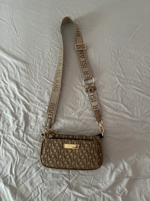 Stone island väska - Säljer nu en av mina favorit väskor. Den är praktisk och har inte bara 1 ficka utan 3 stycken!. Har använts några gånger men är fortfarande i nyskick.Inga defekter. Priset går givetvis att diskutera🫶🏼skriv om ni har frågor