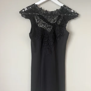 Svart klänning  - Svart klänning med svart spets upptill och knytband i ryggen. Mycket bra skick. Från rök & djurfritt hem. 