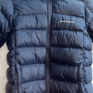 Peakperformence frost down jacka storlek 170 - Storlek 170 Ny pris 2500kr Kan mötas upp i Stockholm  Ett litet hål som är igen sytt på högar arm på baksidan som knappast syns. Skick 6/10 pga ett Hål