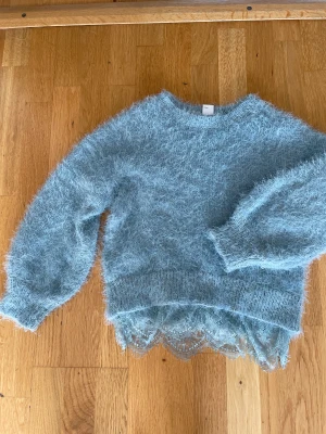 Stickad tröja - Fin stickad tröja med spets nertill. Nyskick.
