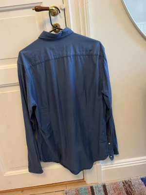 Mörkblå Riley skjorta - En stilren mörkblå skjorta med bröstficka av märket Riley. Köpt på butiken Brothers i fältöversten och inte särskilt använd. Inga fläckar eller hål